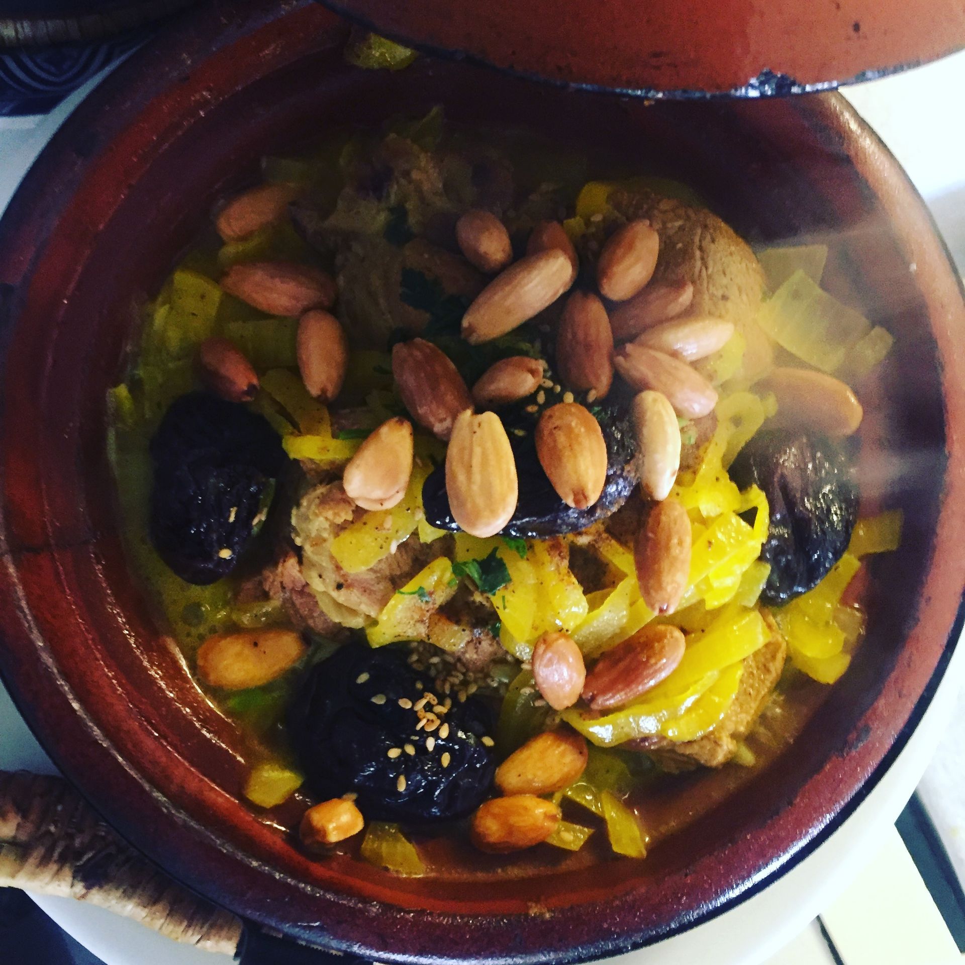 Tajine, plat mijoté avec de la viande, des prunes, des amandes et une sauce cuit dans un pot en terre cuite.
