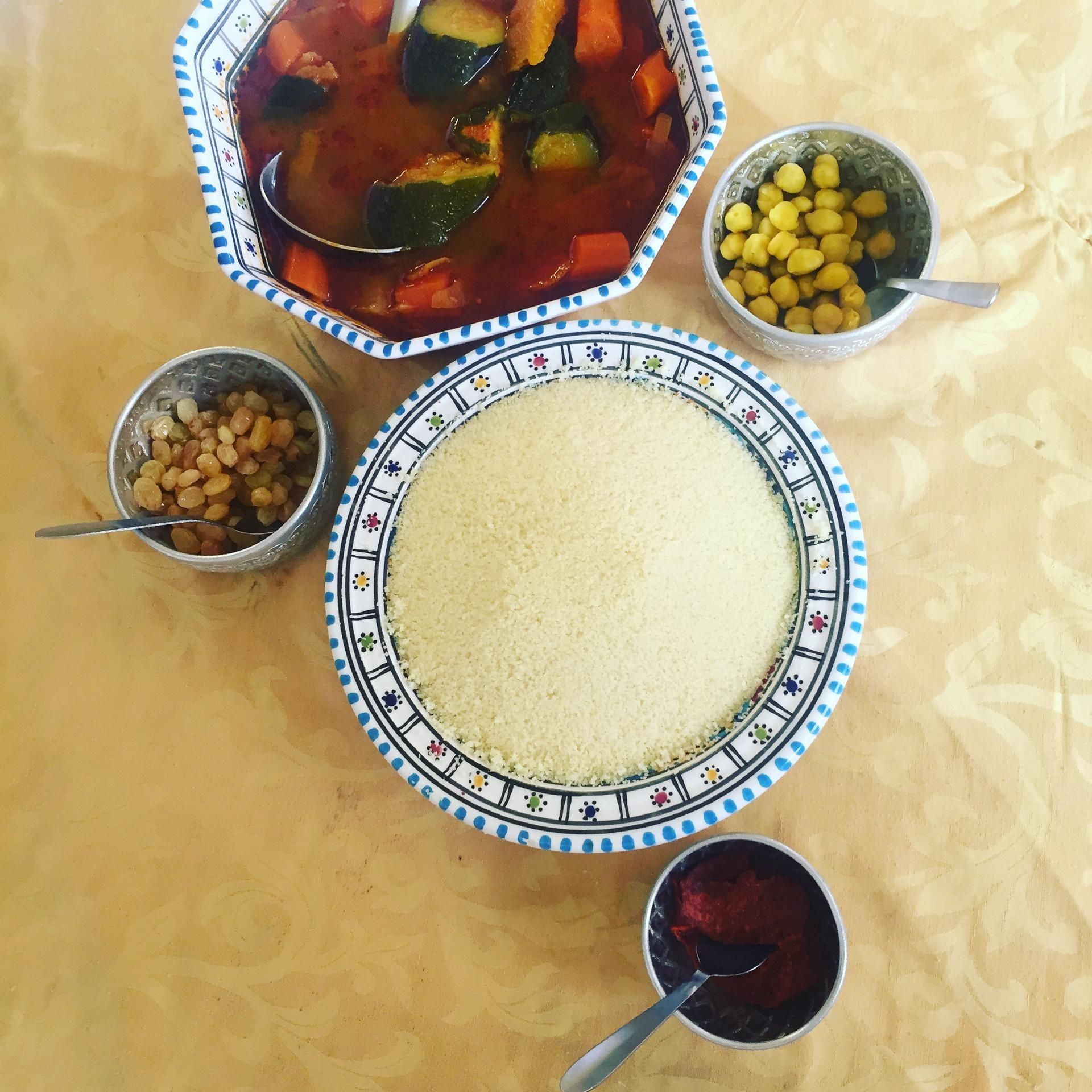 Couscous accompagné d'un ragoût de légumes, de pois chiches, de raisins secs et d'une sauce.