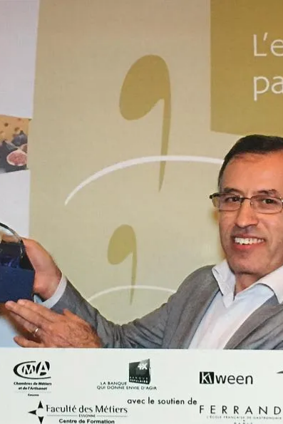 Un homme souriant tient un prix.