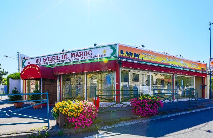 Restaurant Au Soleil du Maroc avec auvent rouge et jardinières.