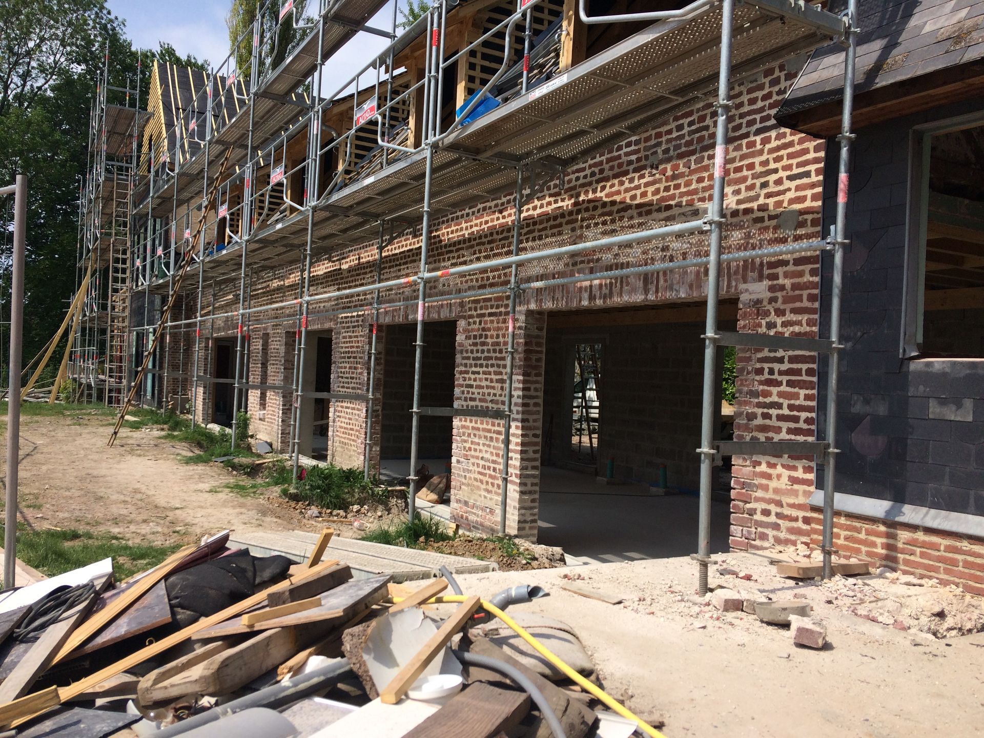 Bâtiment en briques en construction avec échafaudages.