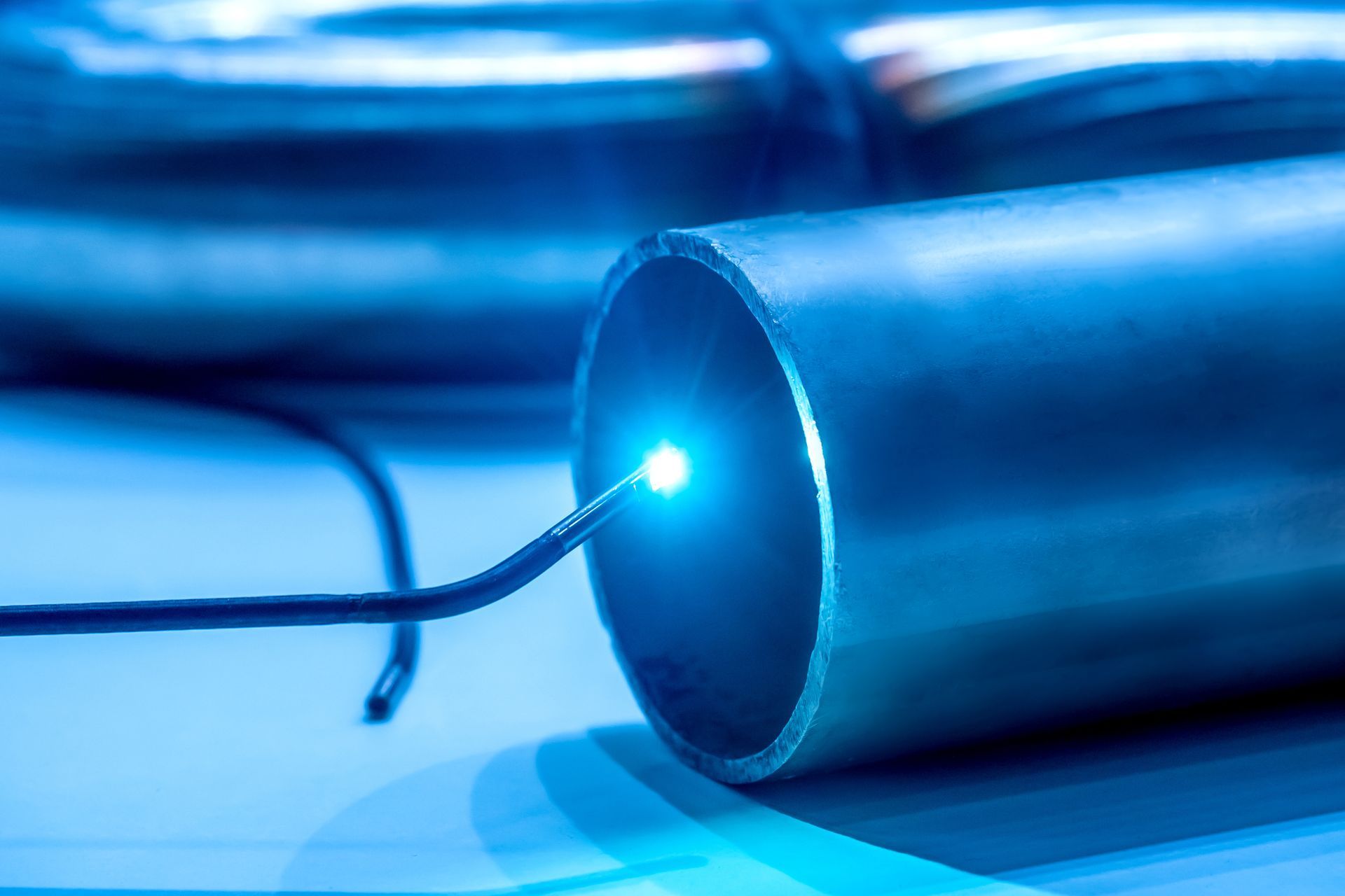 Un câble électrique bleu illumine un tuyau creux