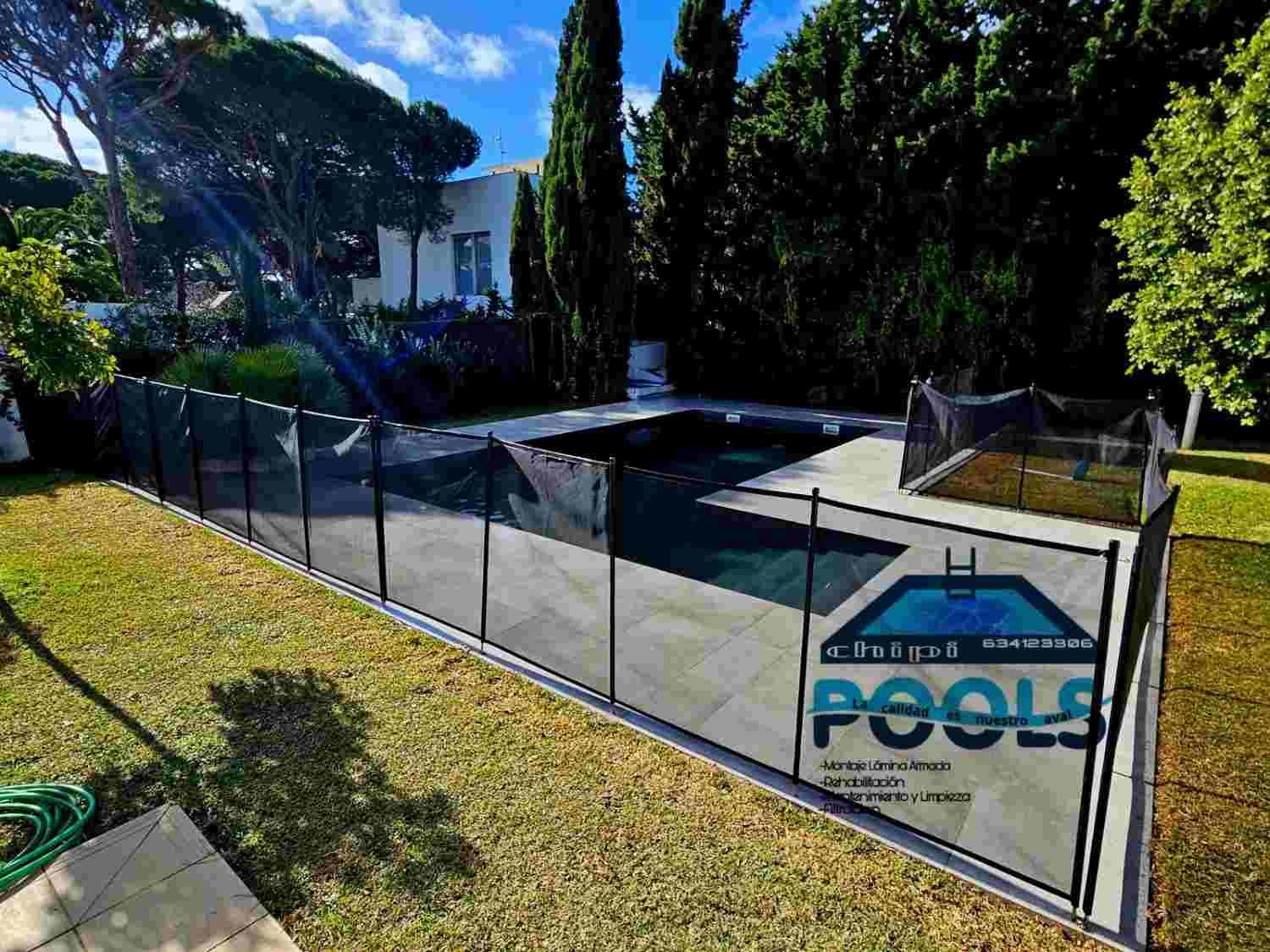 Zona de piscina en el patio trasero, con una valla de