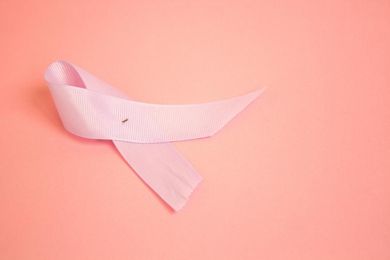 Cinta rosa sobre fondo coral, que simboliza la concienciación sobre el cáncer de mama.