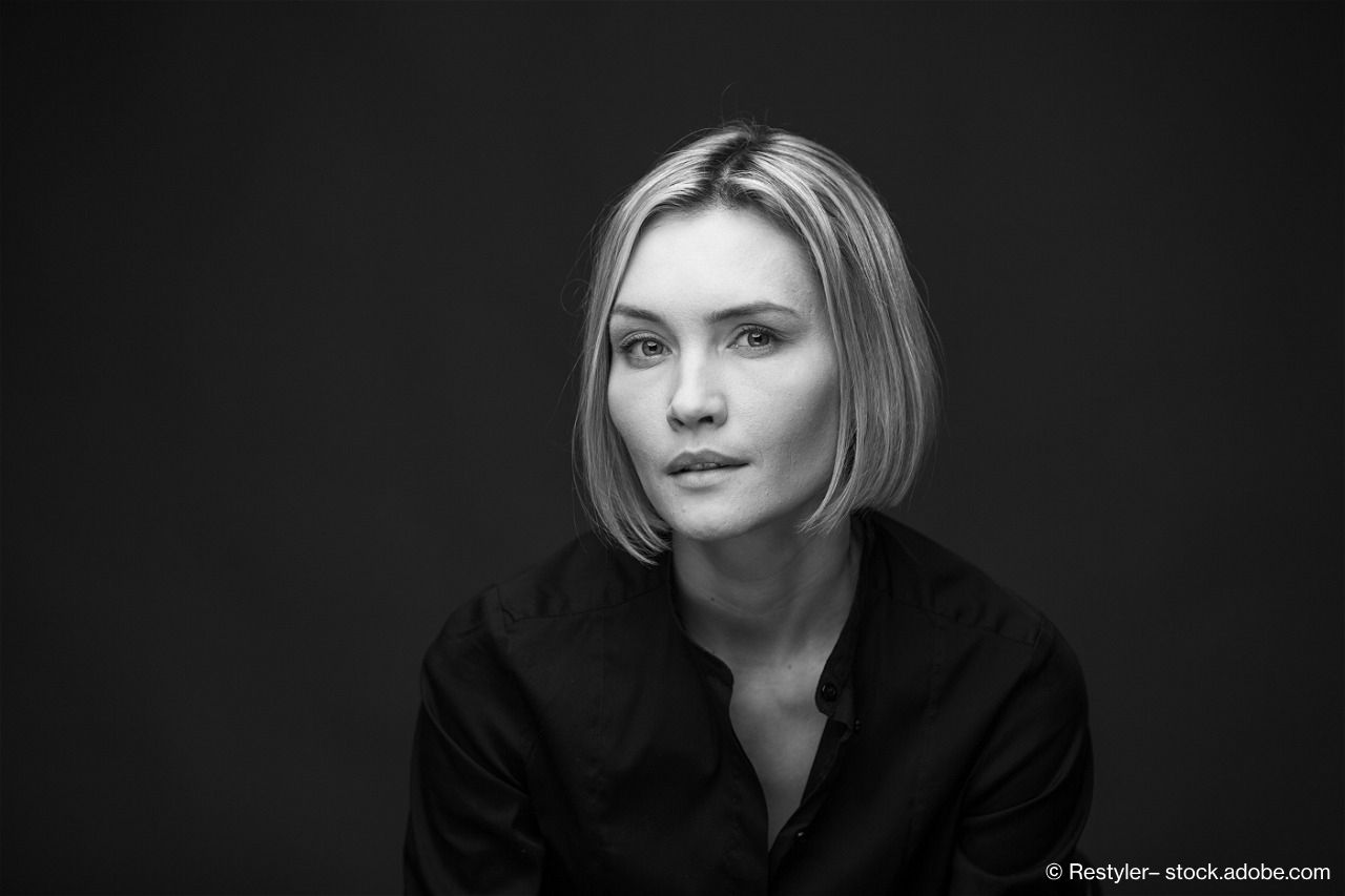 Ernst blickende Frau mit mittellangen, blonden Haaren in Schwarz-Weiß.