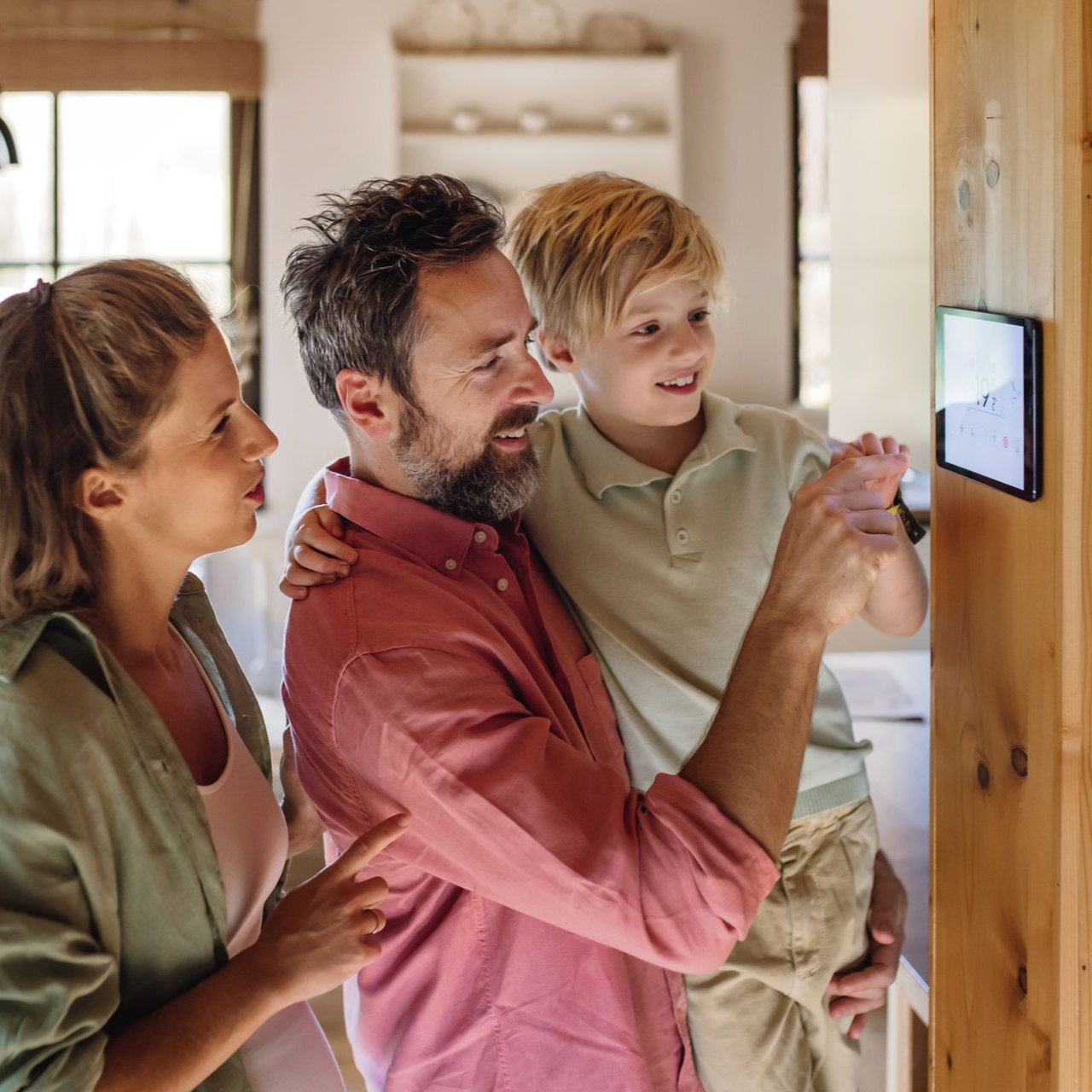 Une famille utilise un écran tactile mural dans un intérieur lumineux.
