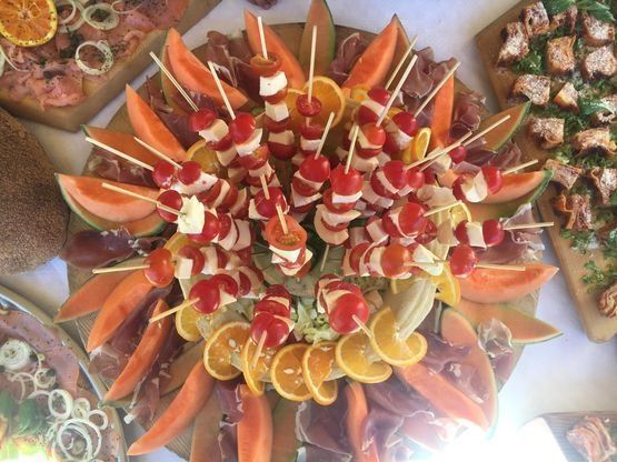 Ein Tisch mit Tellern voller Essen, darunter Fleisch- und Obstspiesse. Foto von der CRUSCH Trattoria, Pizzeria, Specialità Italiane GmbH