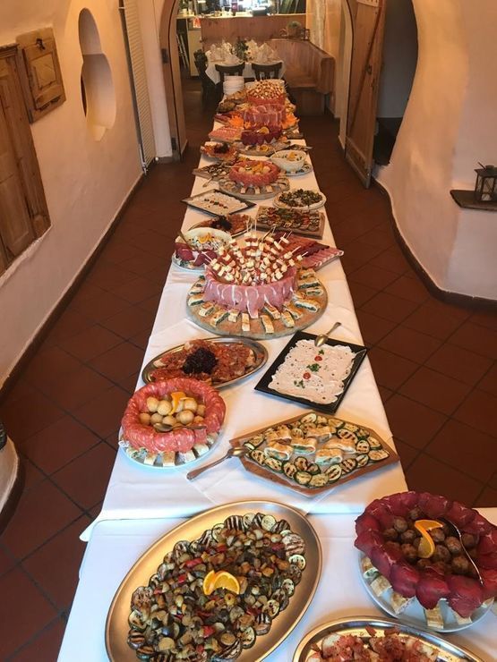 Ein langer Buffet-Tisch mit viel Essen darauf. Foto von der CRUSCH Trattoria, Pizzeria, Specialità Italiane GmbH