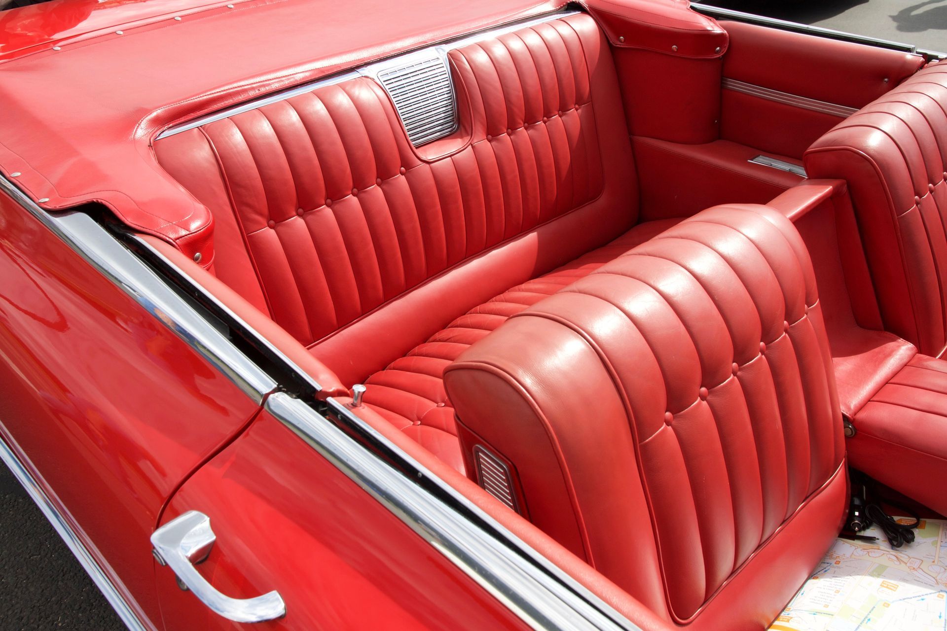 Intérieur en cuir rouge avec deux sièges baquets et une banquette dans une voiture de collection décapotable