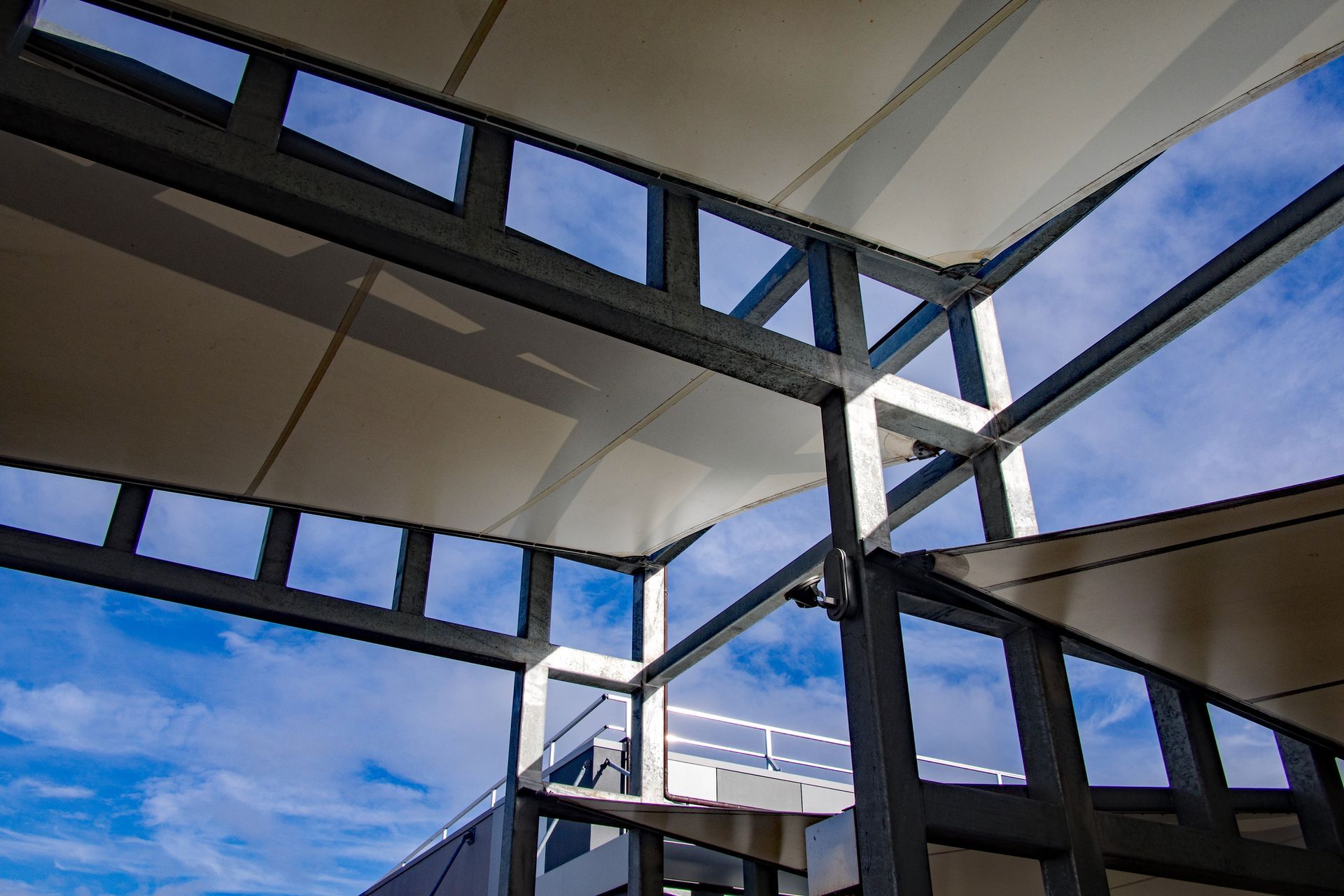 Extérieur d'un bâtiment moderne avec poutres et de grandes bâches blanches tendues
