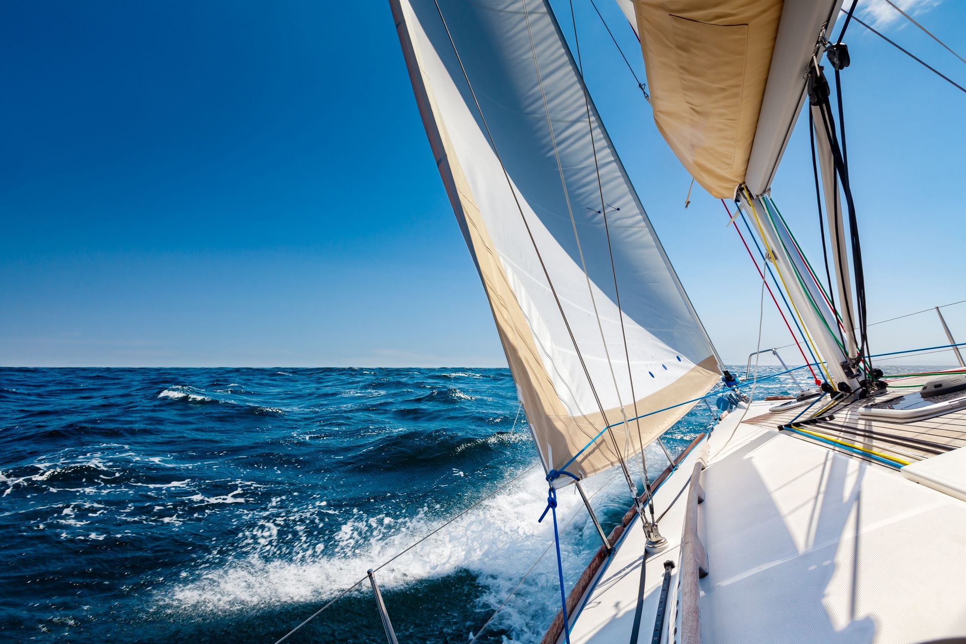 Voilier en mer sous un ciel clair, voiles gonflées par le vent
