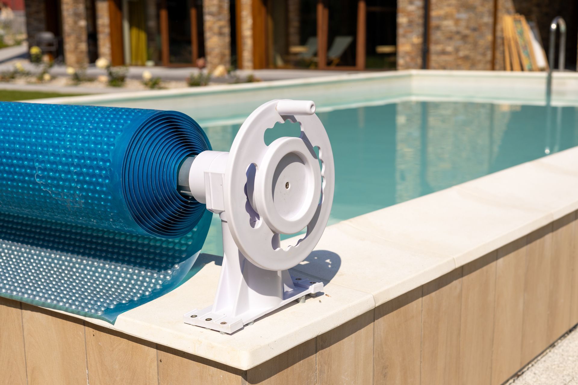 Enrouleur de couverture de piscine bleue sur le bord d'une piscine extérieure