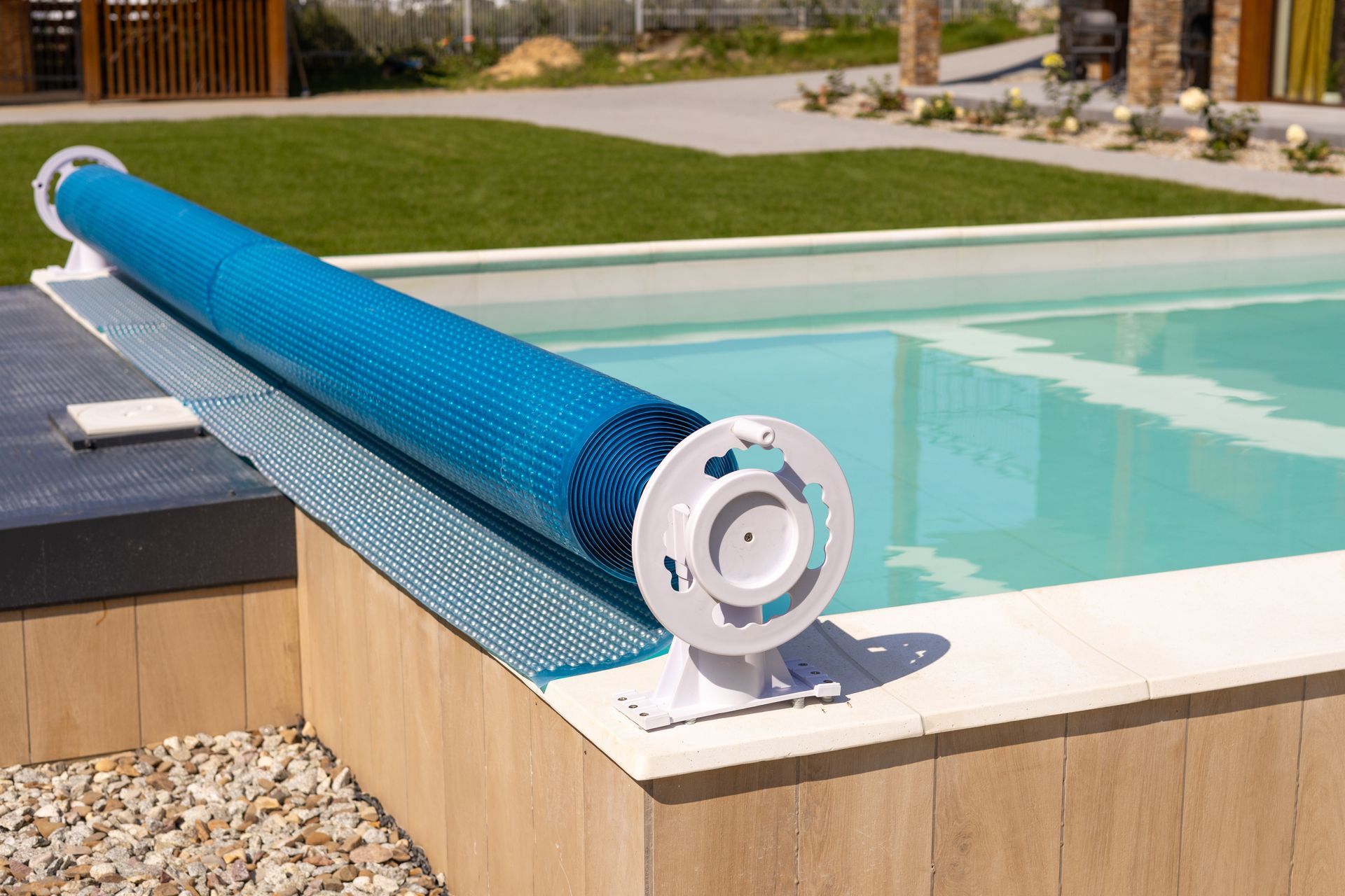 Enrouleur de bâche de piscine bleue sur le bord d'une piscine