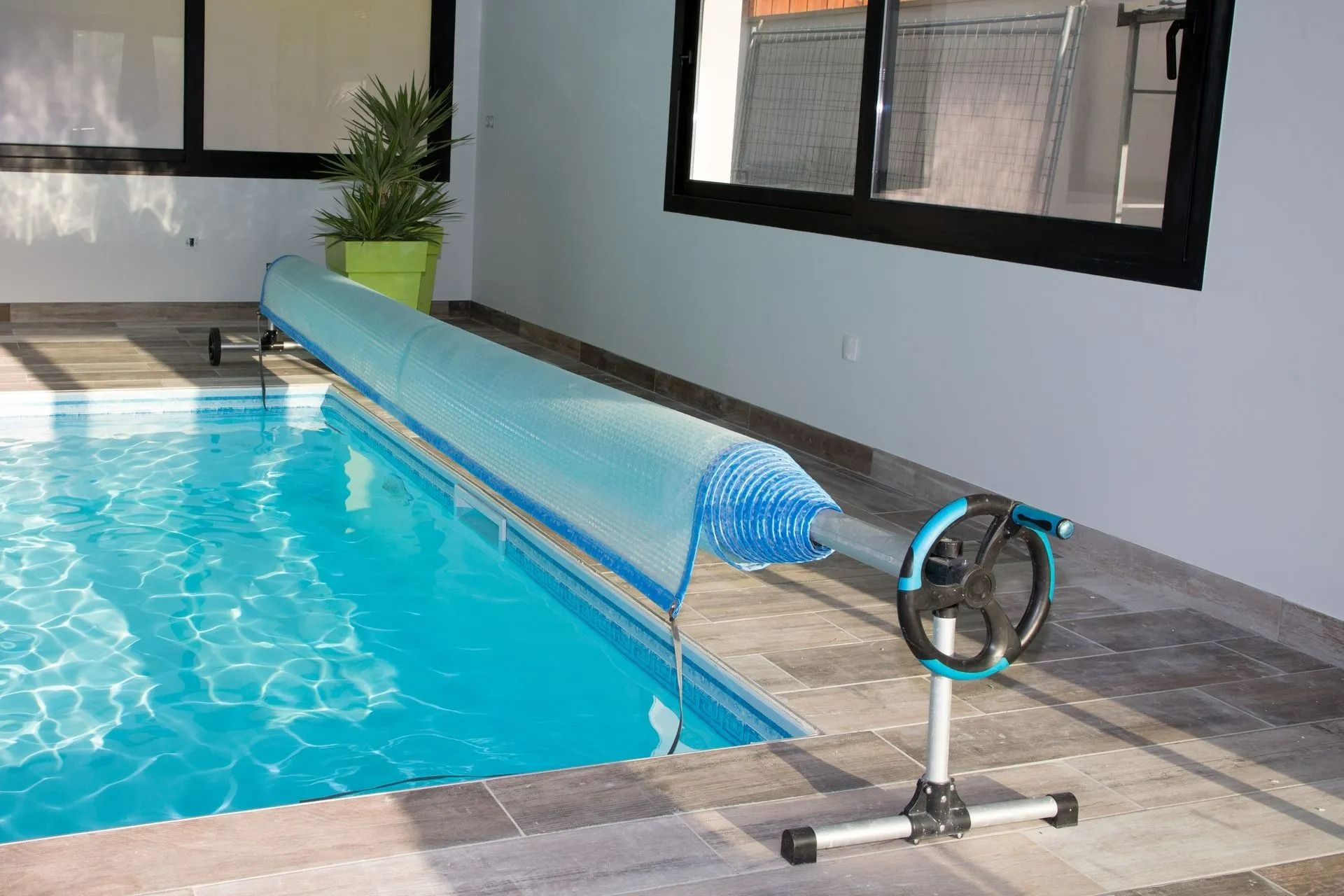 Enrouleur de bâche bleue d'une piscine intérieure