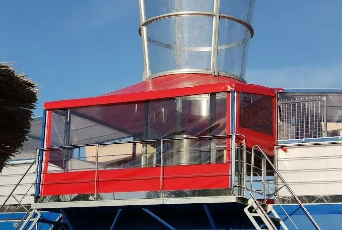 Cabine d'observation métallique avec une bâche rouge avec des fenêtres.