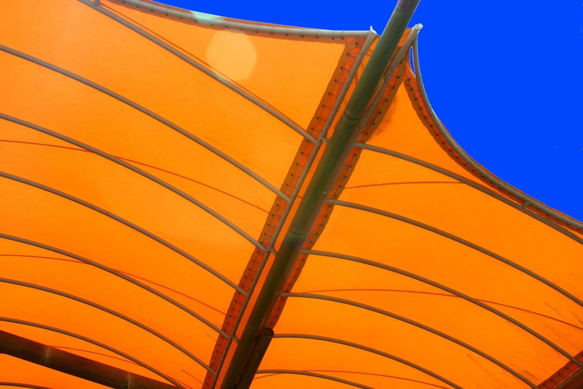 Un voilage orange se détachant sur un ciel bleu éclatant