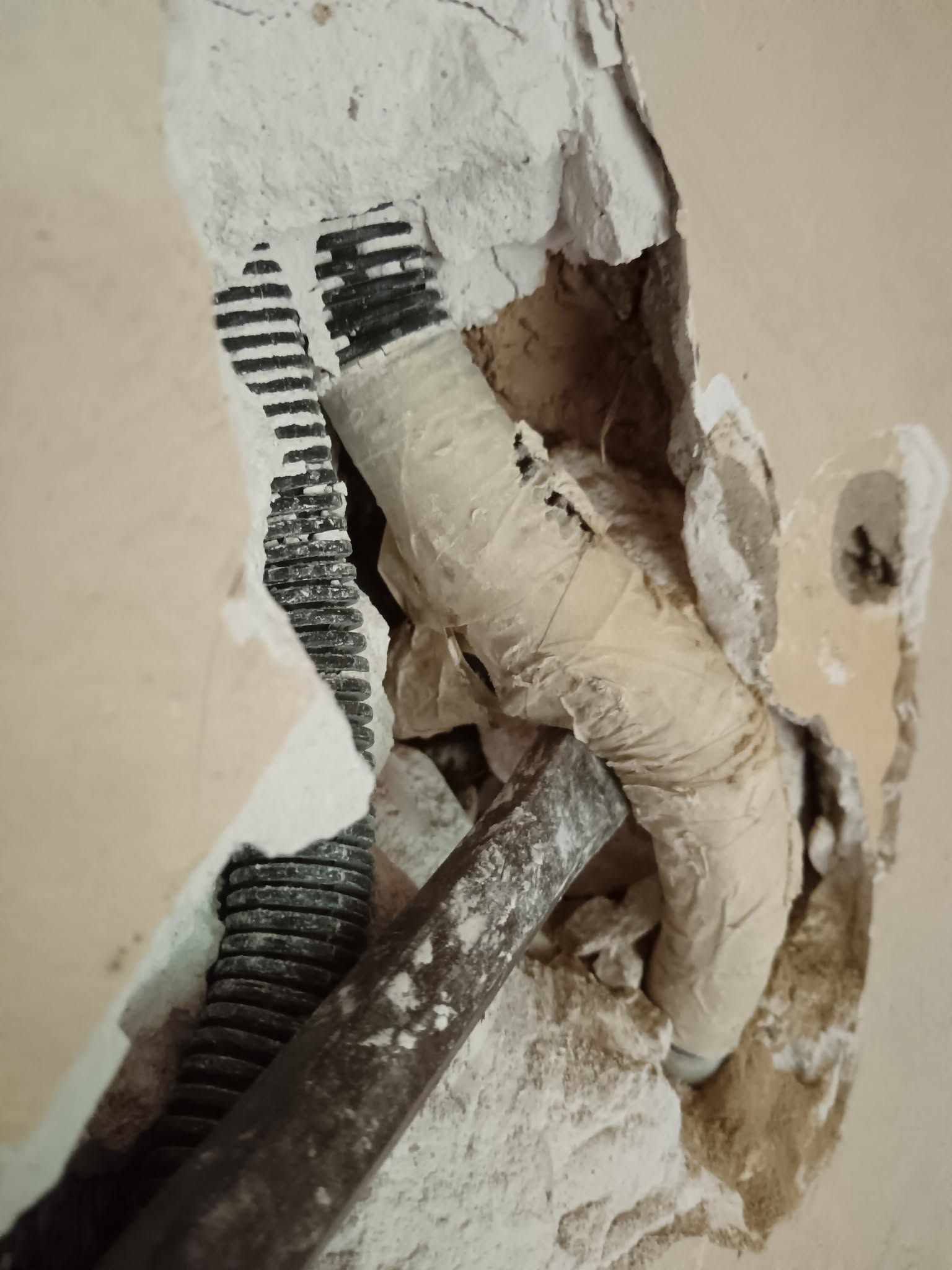 Ouverture d'un mur en plâtre pour rechercher une panne électrique.