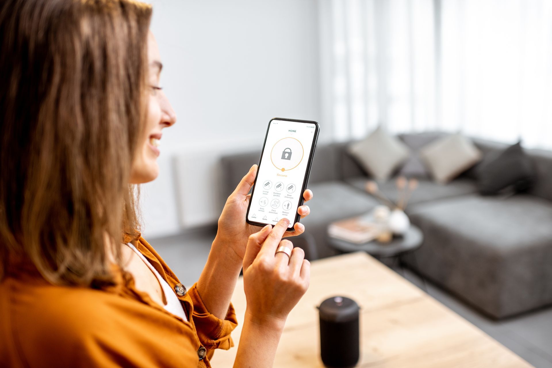 Une femme utilise une application de domotique sur son smartphone.