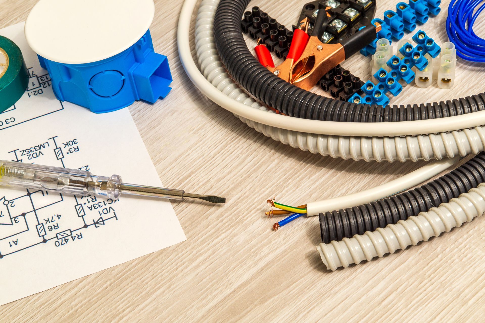 Des outils pour travaux électriques sur une table en bois.