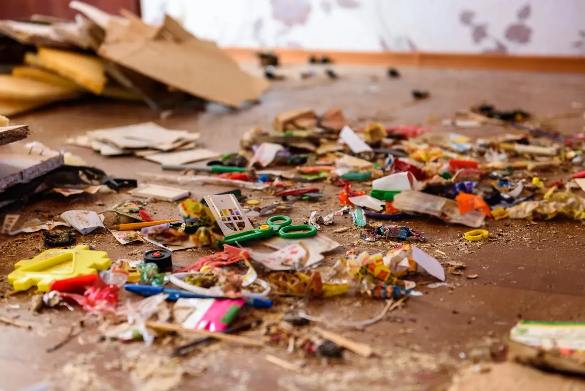 Escombros esparcidos por el suelo, entre cartón y trozos de plástico de colores, en el interior.