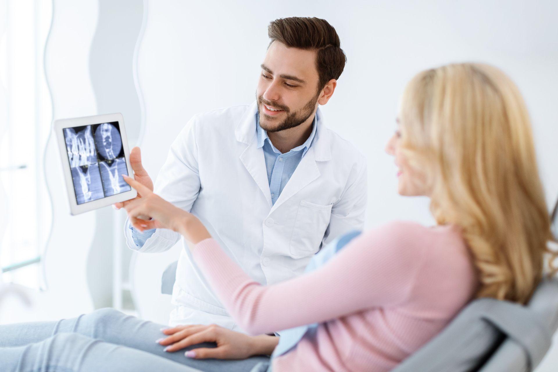 Patientin schaut Ihr Röntgen an beim Zahnarzt