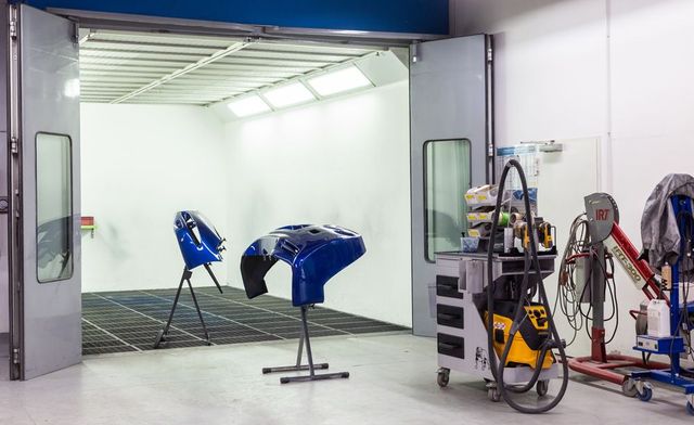 In einer Lackierkabine in einer Garage wird ein Auto lackiert.
