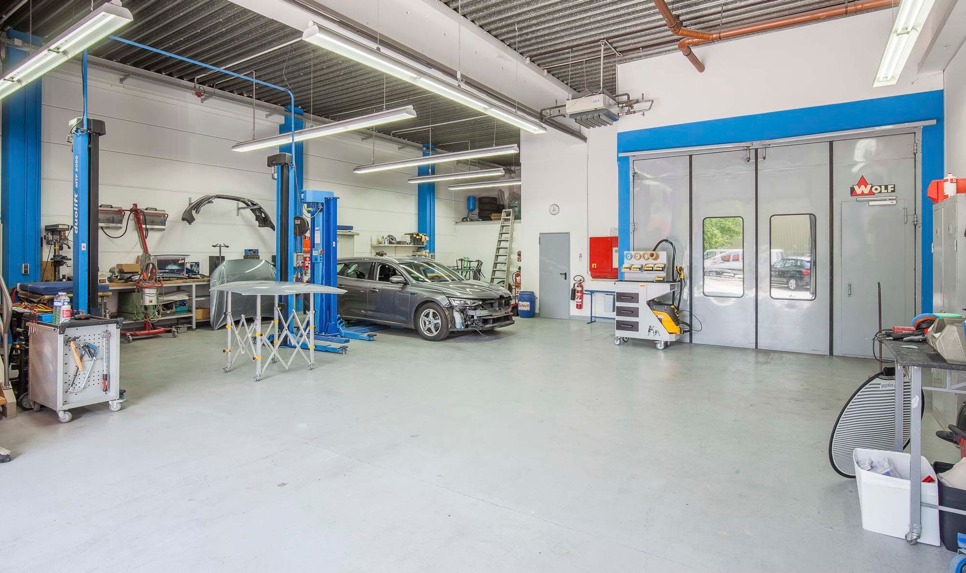 Ein Auto steht auf einer Hebebühne in einer Garage.