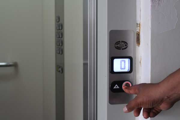 A pessoa pressiona a seta para cima para que o elevador suba para outro andar.