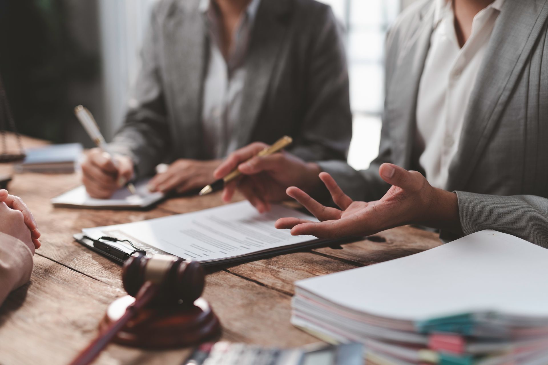 Des avocats discutent et prennent des notes autour d'une table de conférence.
