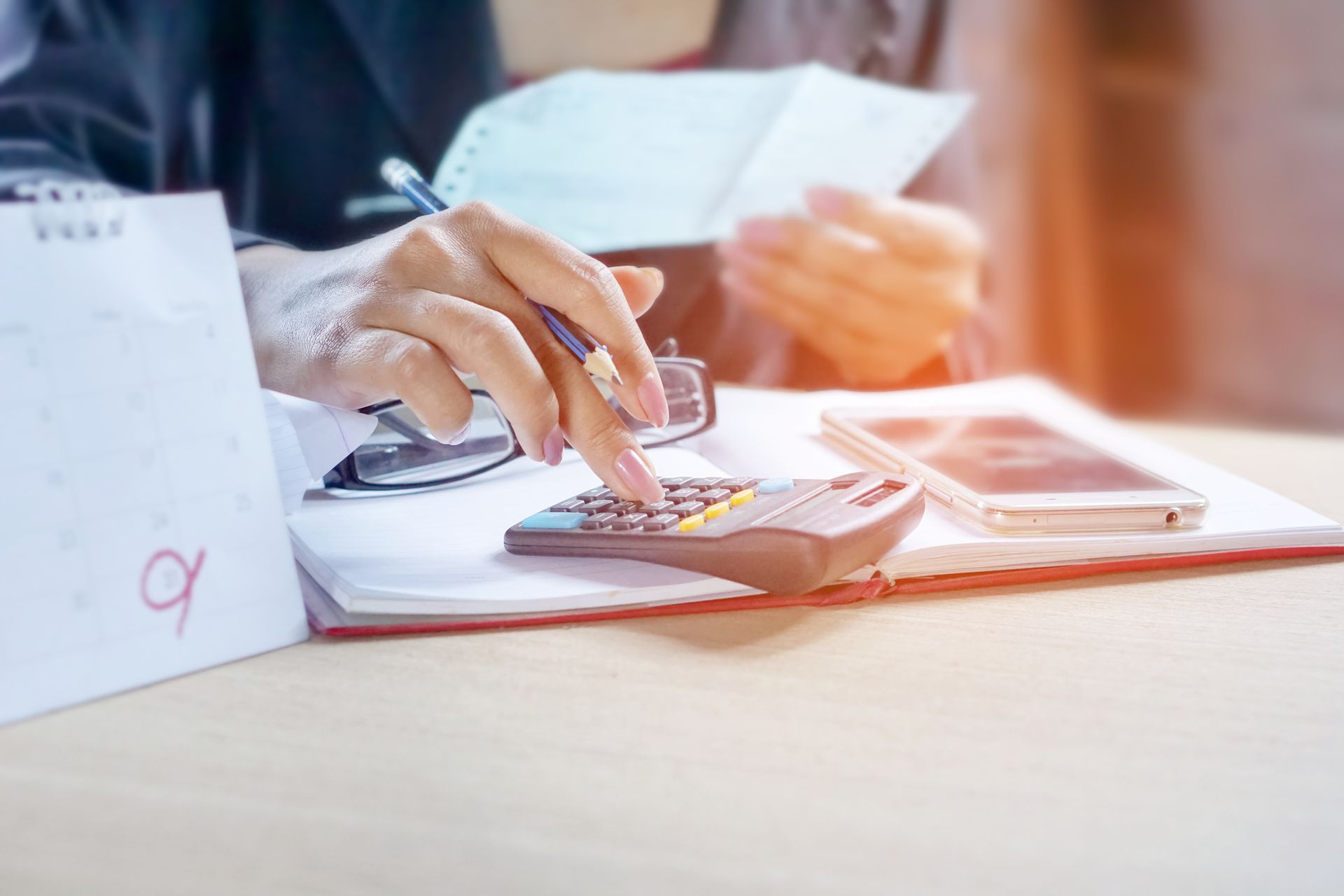 Un avocat exécute des calculs à son bureau, à l'aide d'une calculatrice.