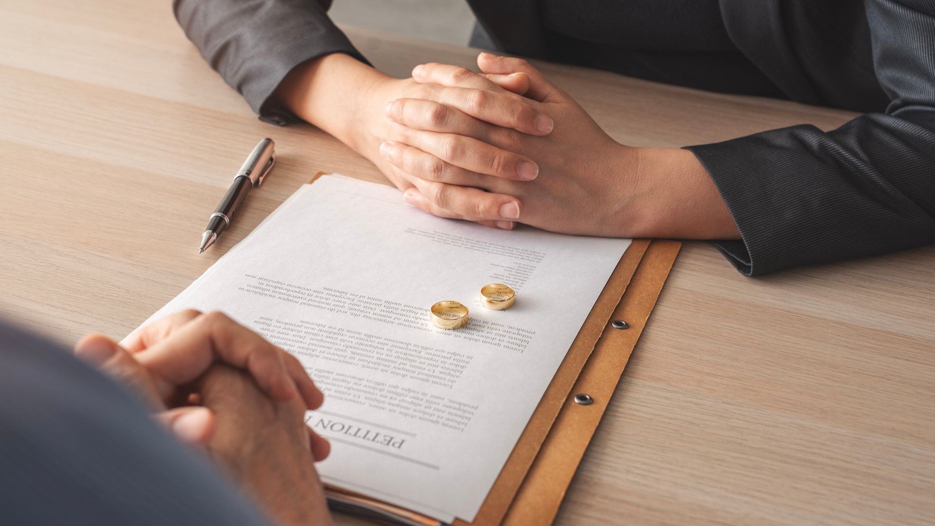 Deux personnes examinent un document et des alliances en or.