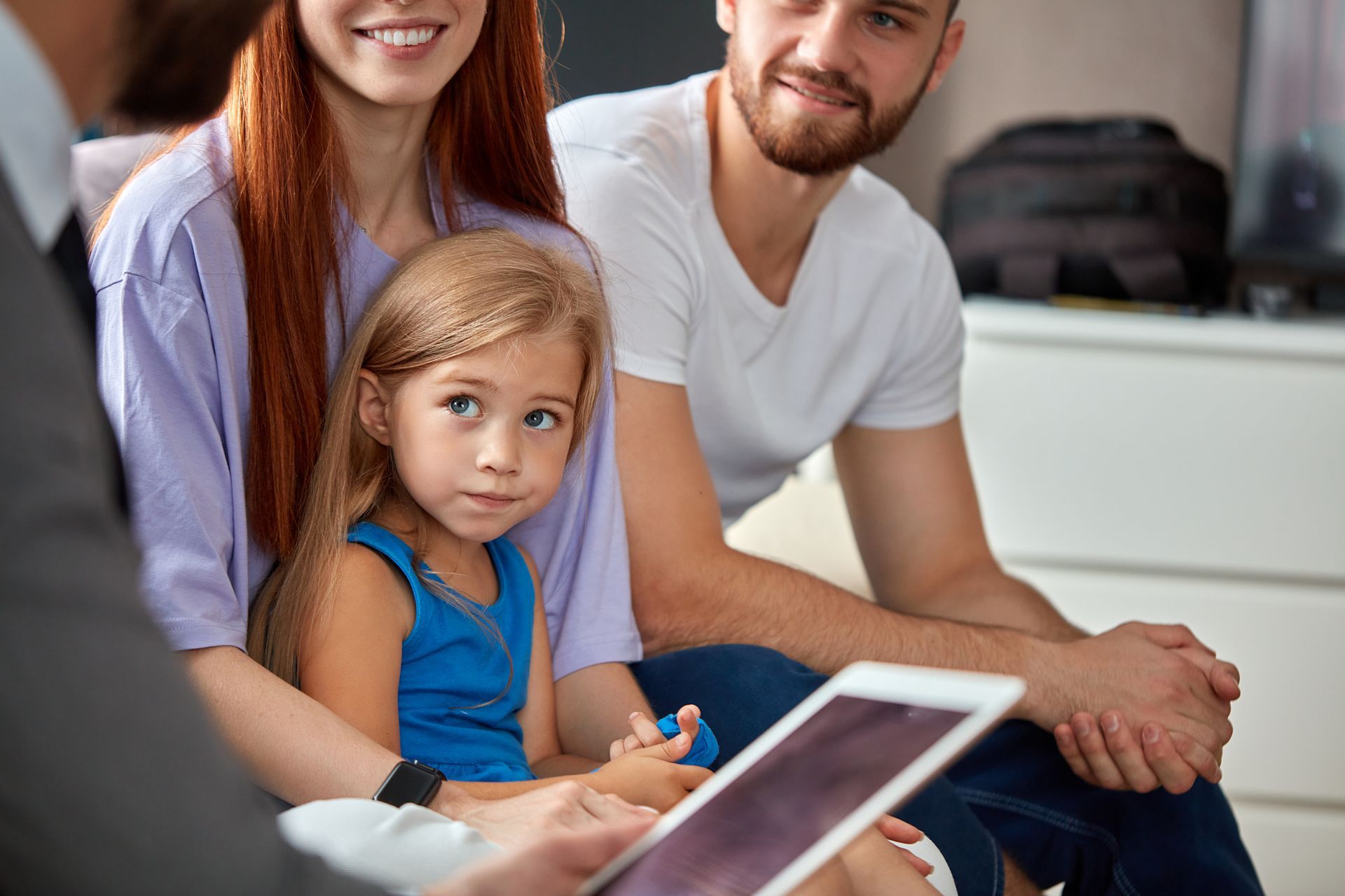 Une famille assise ensemble sur un canapé, consultant un avocat.