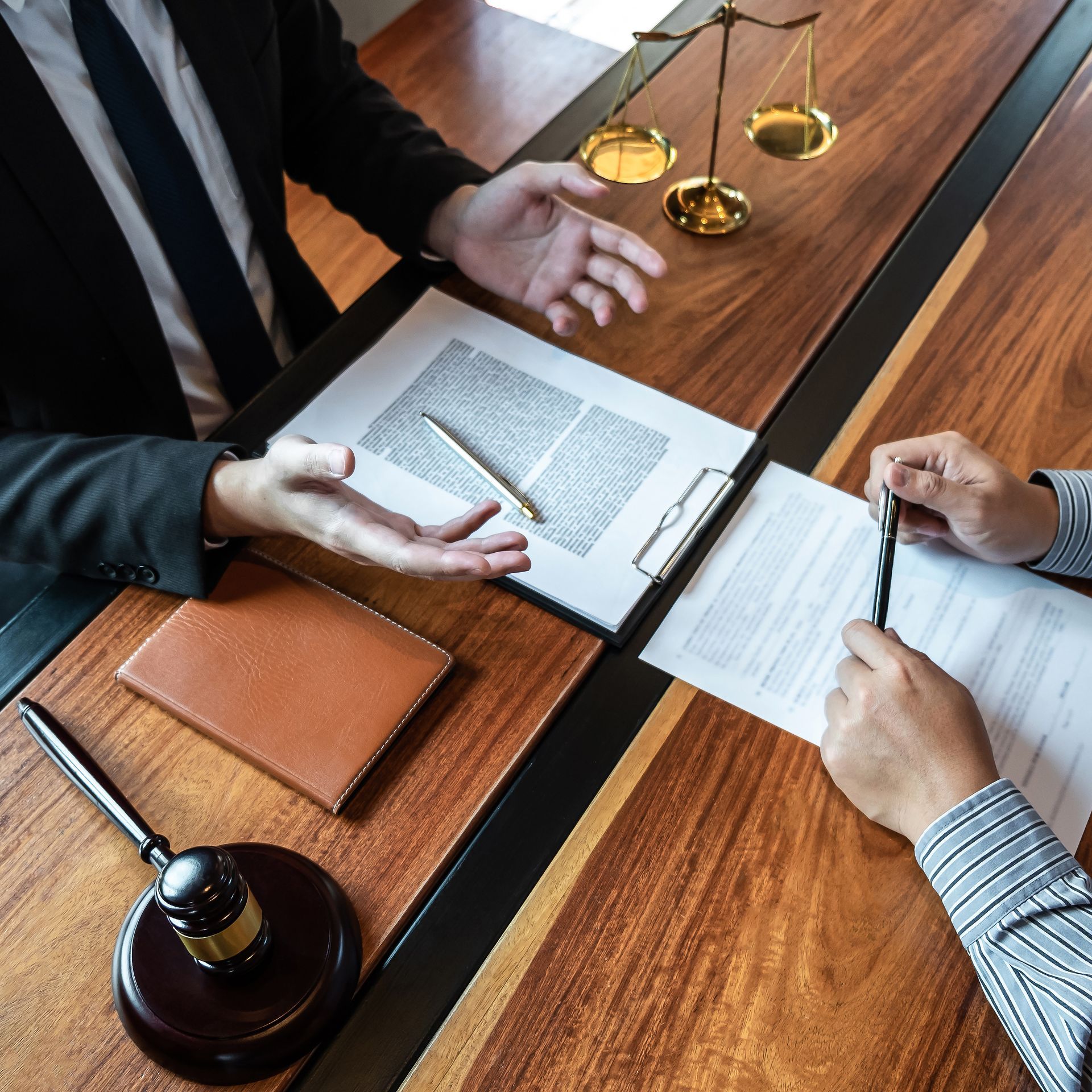 Deux personnes examinent des documents autour d'une table de conférence en bois.