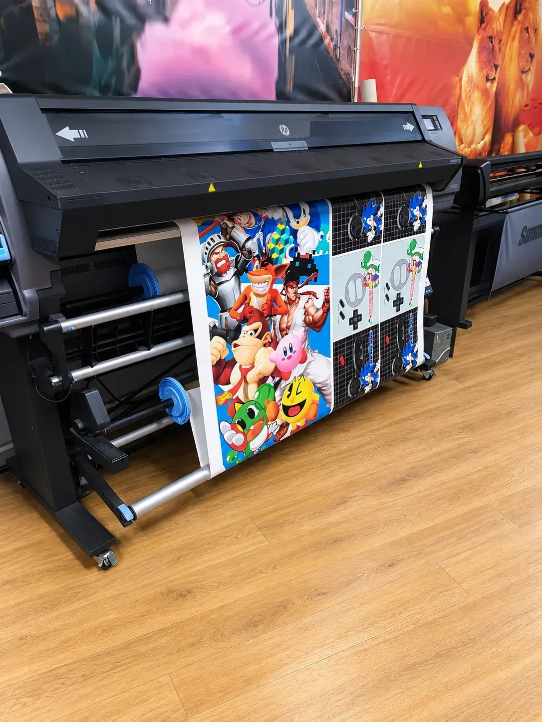 Impresora de gran formato imprimiendo coloridos carteles estilo cómic en una imprenta.