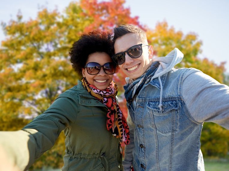 Un hombre y una mujer se toman un selfie en un parque.