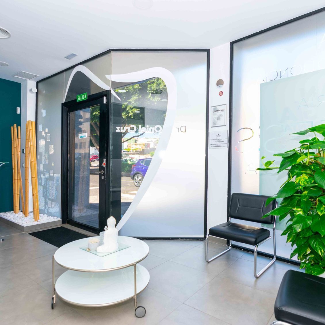 Una sala de espera en un consultorio dental con una mesa y sillas.