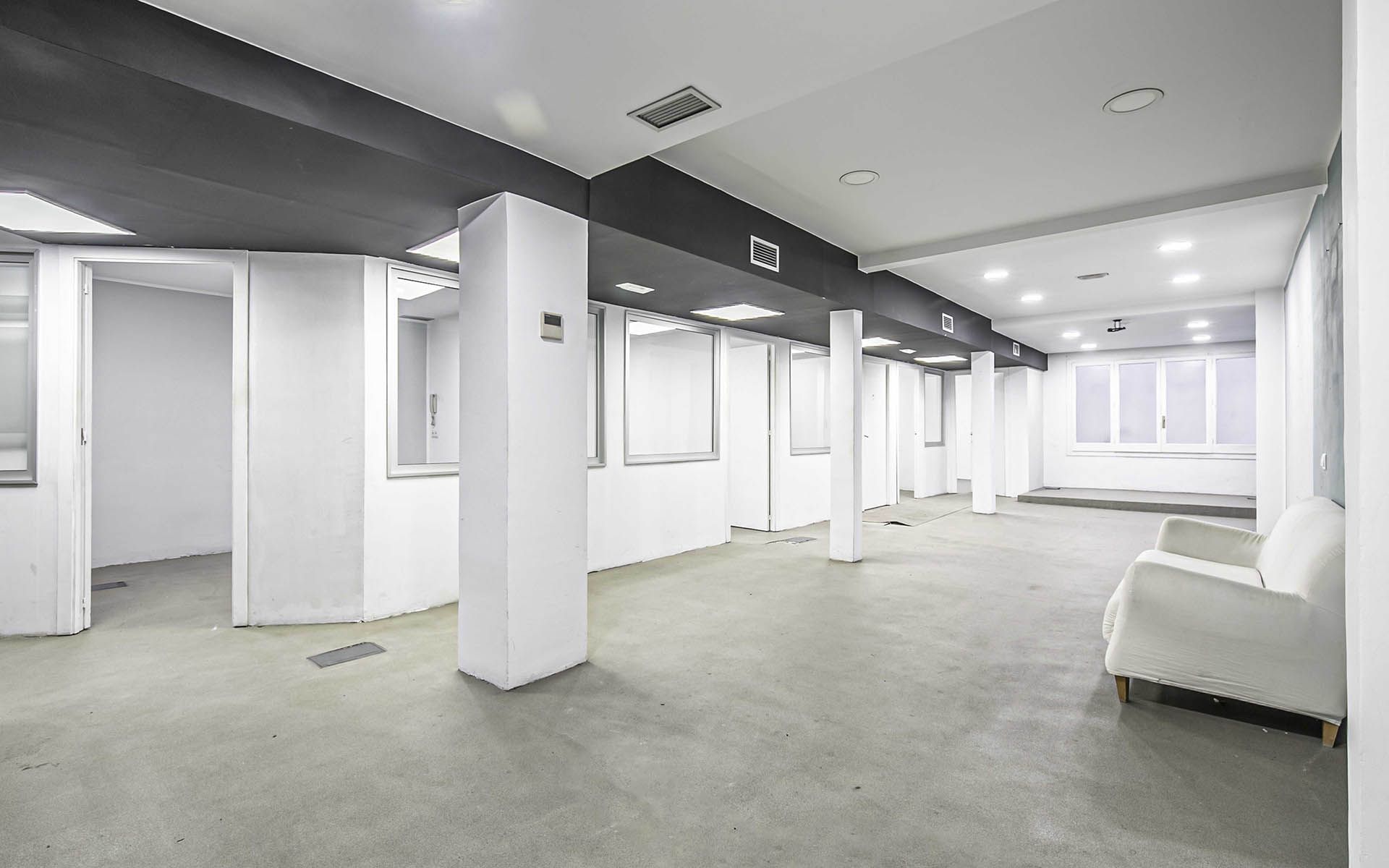 Una gran habitación vacía con paredes y columnas blancas.