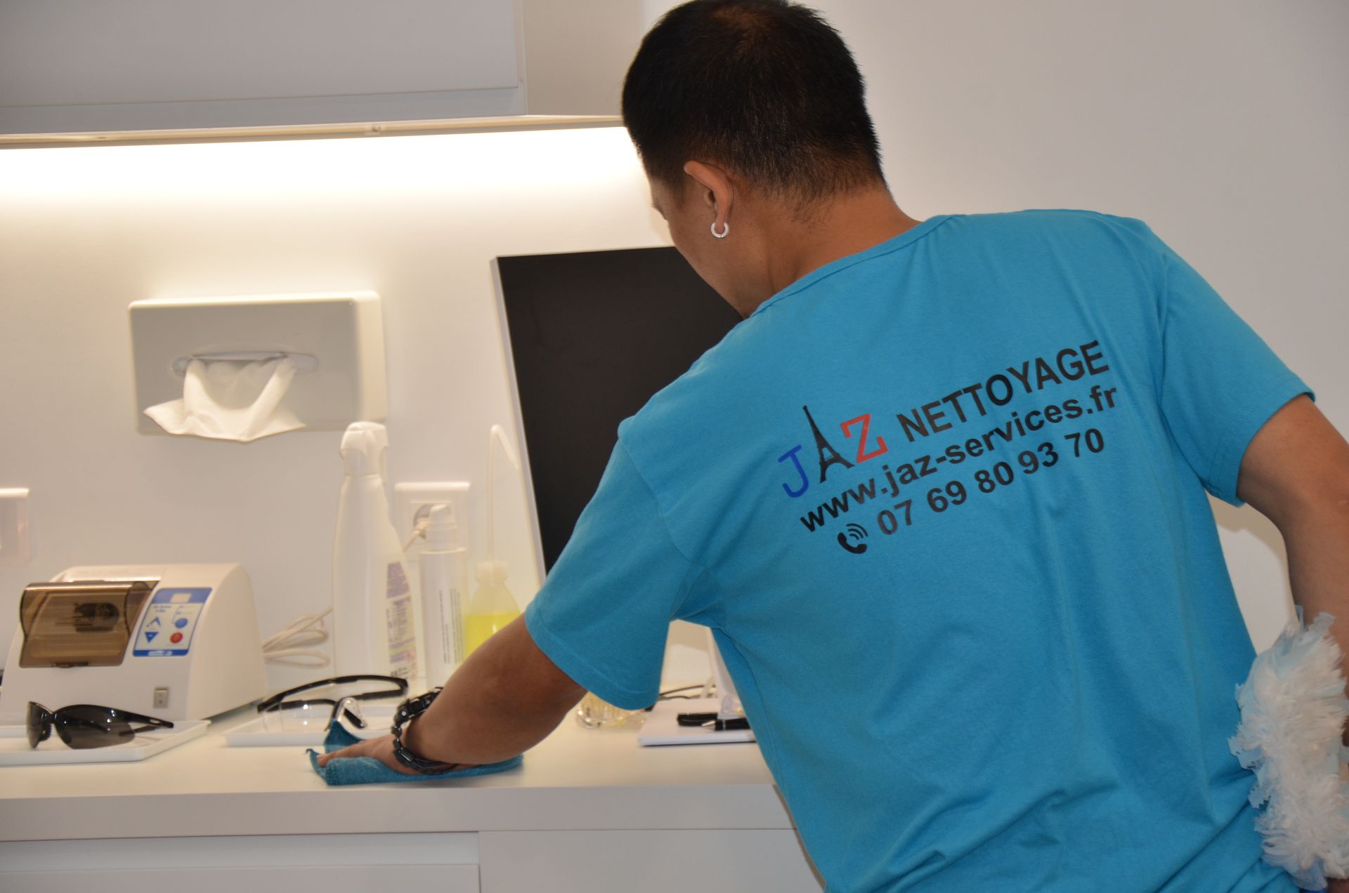 Homme qui nettoie le plan de travail d'un dentiste.