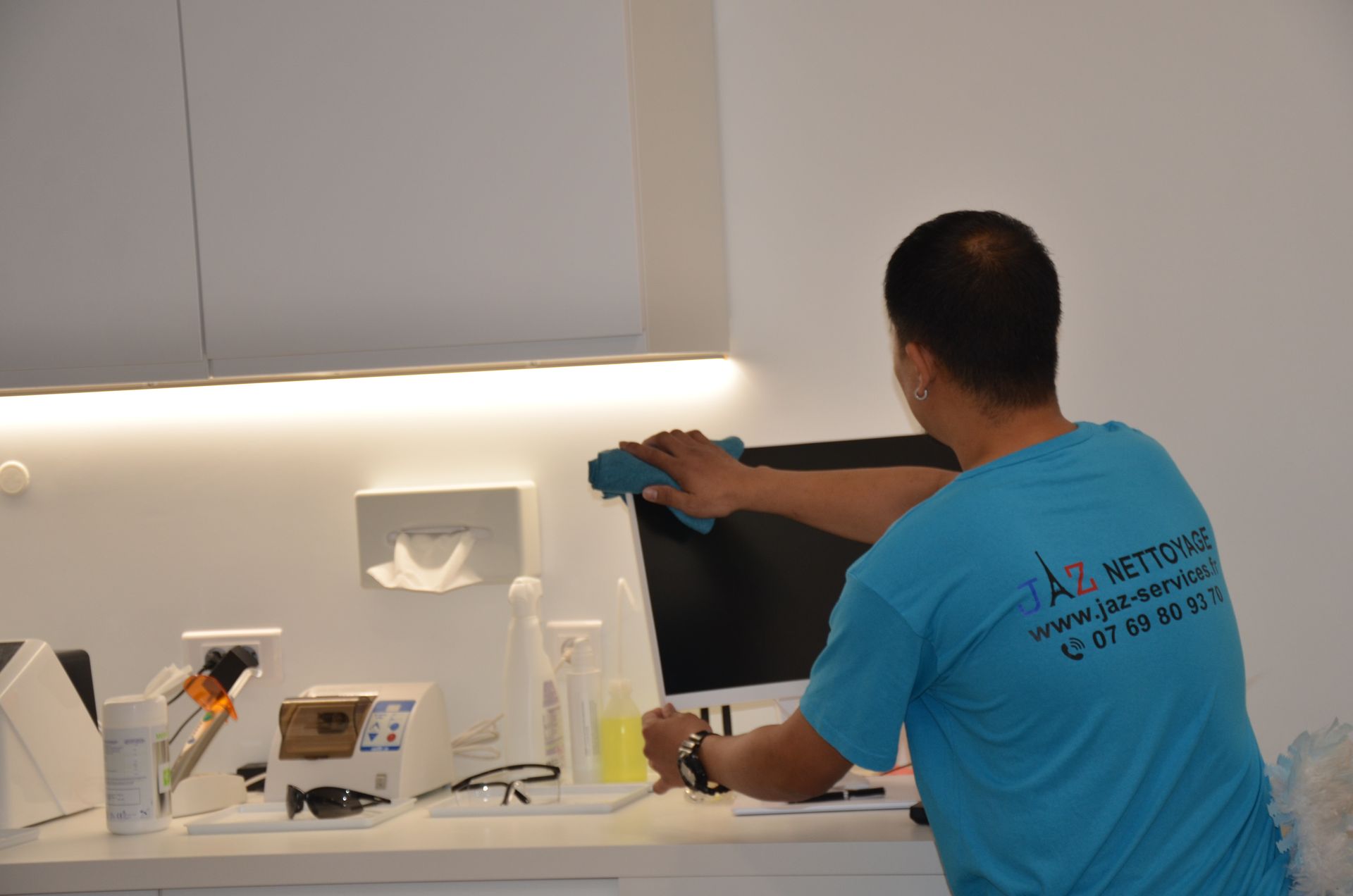 Homme qui nettoie le poste de travail d'un cabinet dentaire.
