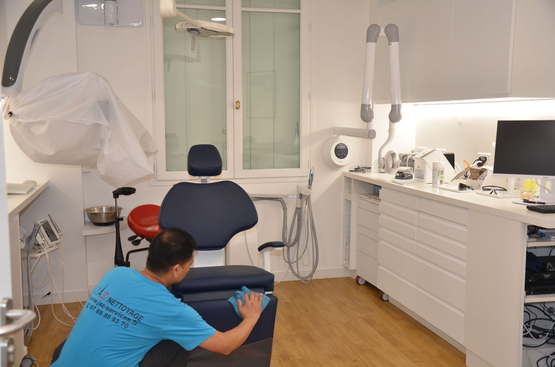 Homme qui passe le chiffon sur un fauteuil de dentiste.