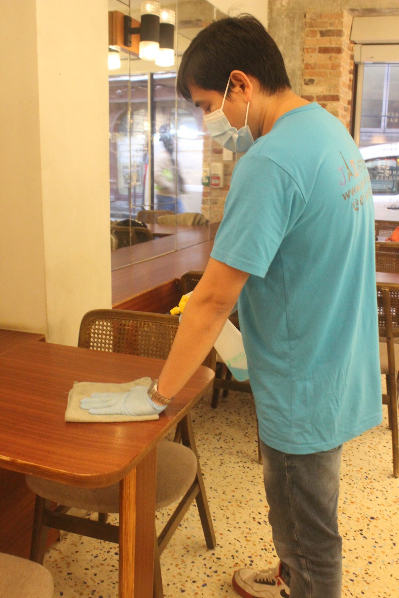 Homme qui nettoie la table d'un restaurant.