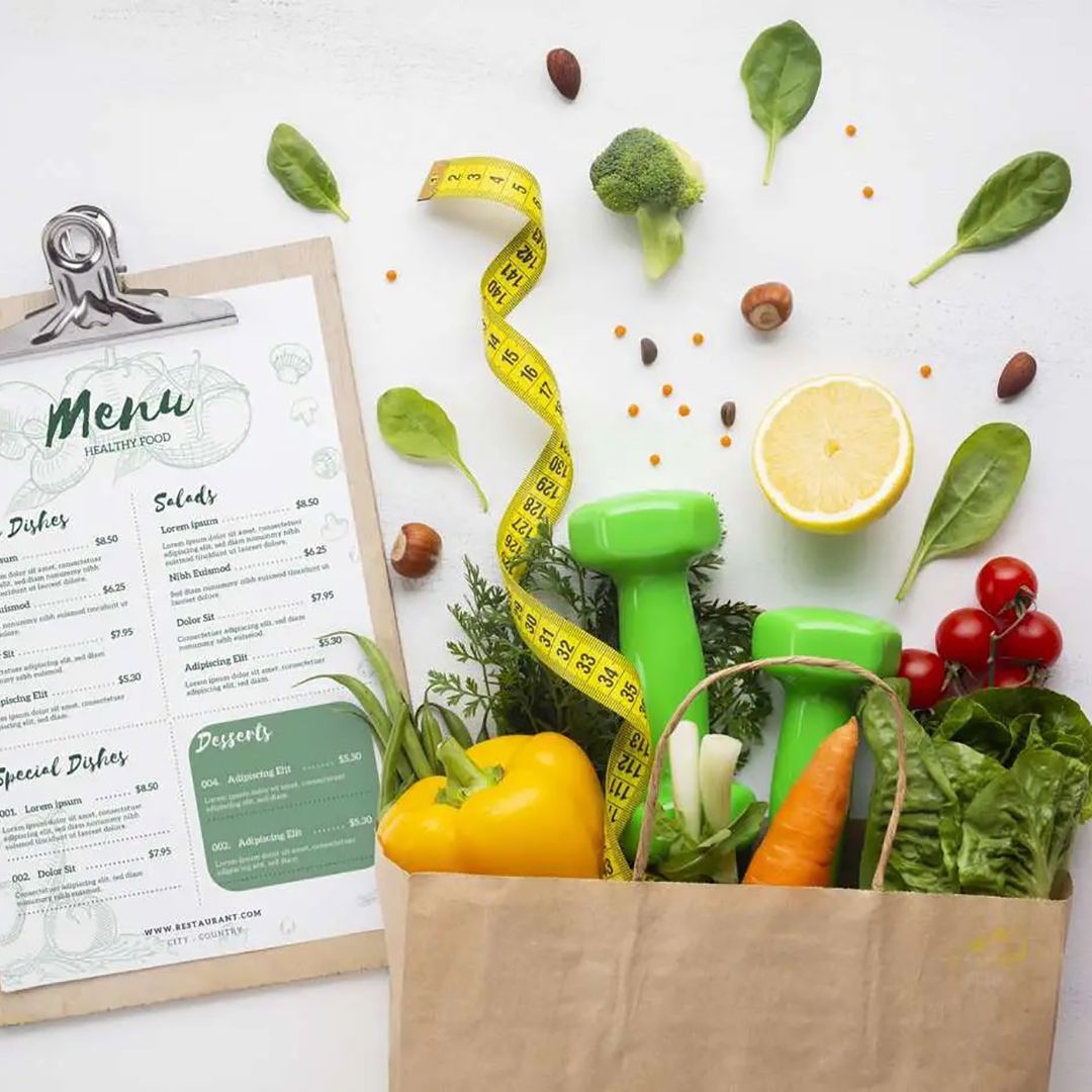 Sacchetto di carta pieno di verdure, manubri e metro a nastro; menu su un blocco appunti.