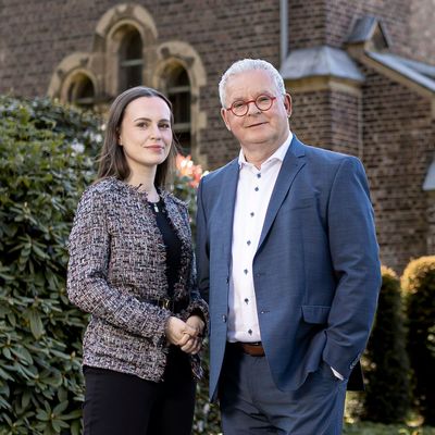 Ein Mann in Anzug und Krawatte lächelt in die Kamera