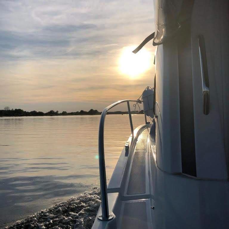 Die Sonne geht hinter einem Boot im Wasser unter