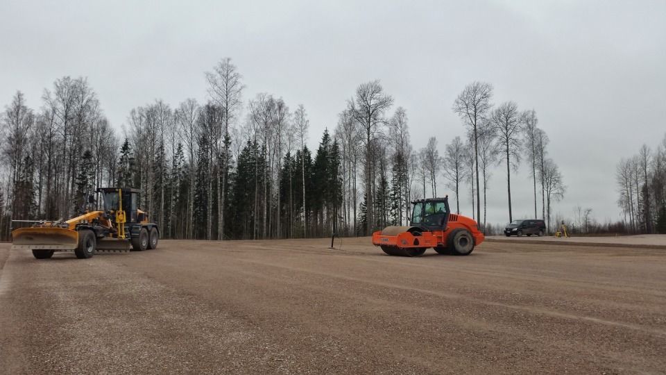 Tiehöylä työmaalla metsäalueella tekemässä asfaltoinnin pohjatöitä