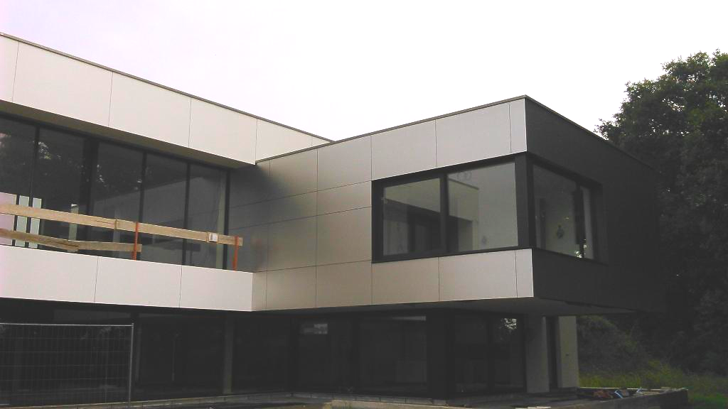 Bâtiment moderne de deux étages avec des panneaux et de grandes fenêtres.