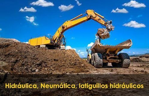 Una excavadora amarilla está cargando tierra en un camión volquete.