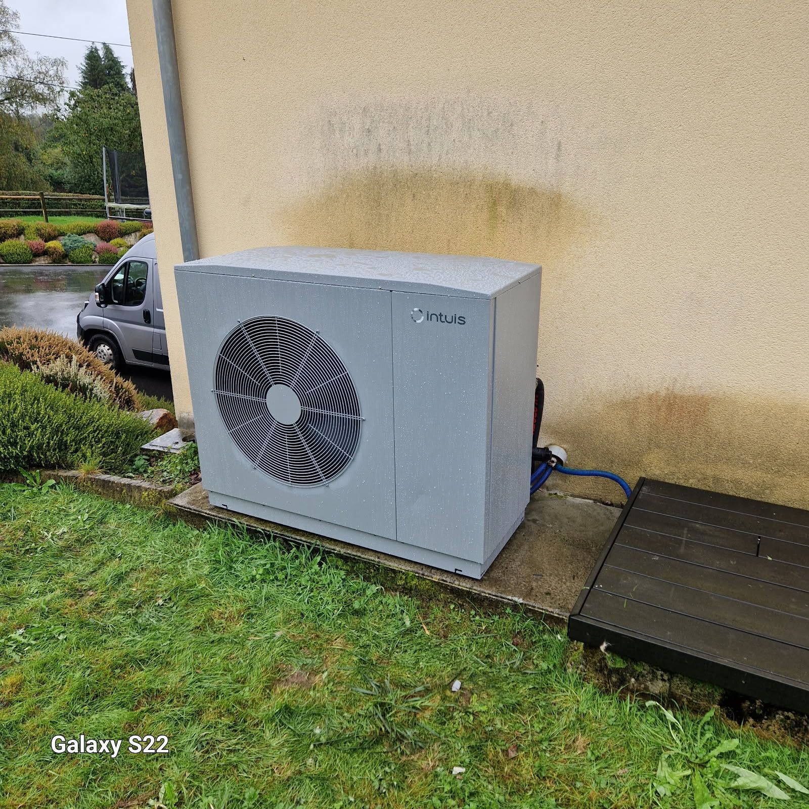 Un homme en casquette devant deux pompes à chaleur