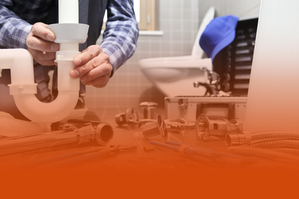 Un plombier qui répare un tuyau d'évacuation