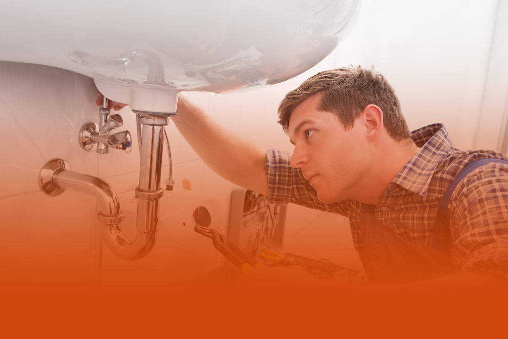 Un plombier sous un évier
